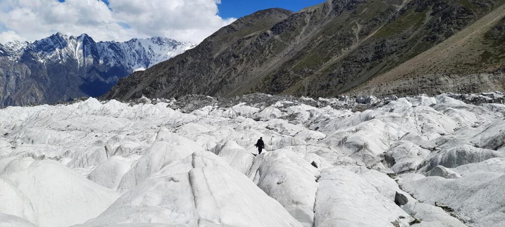 Hiker walking across glacier ice