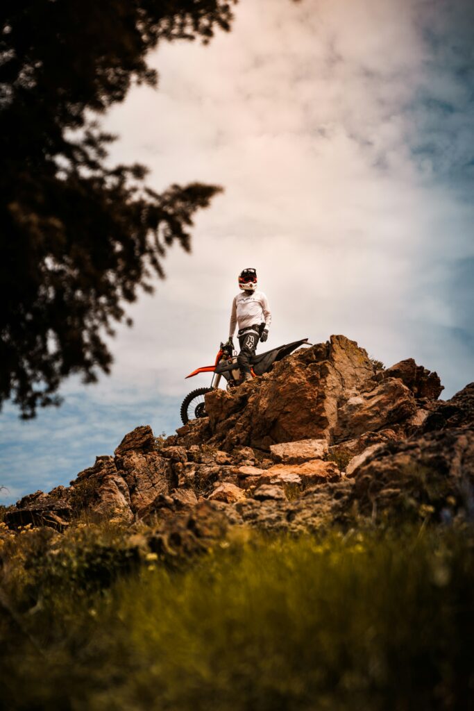 Motorbike rider beside a rocky mountain slope