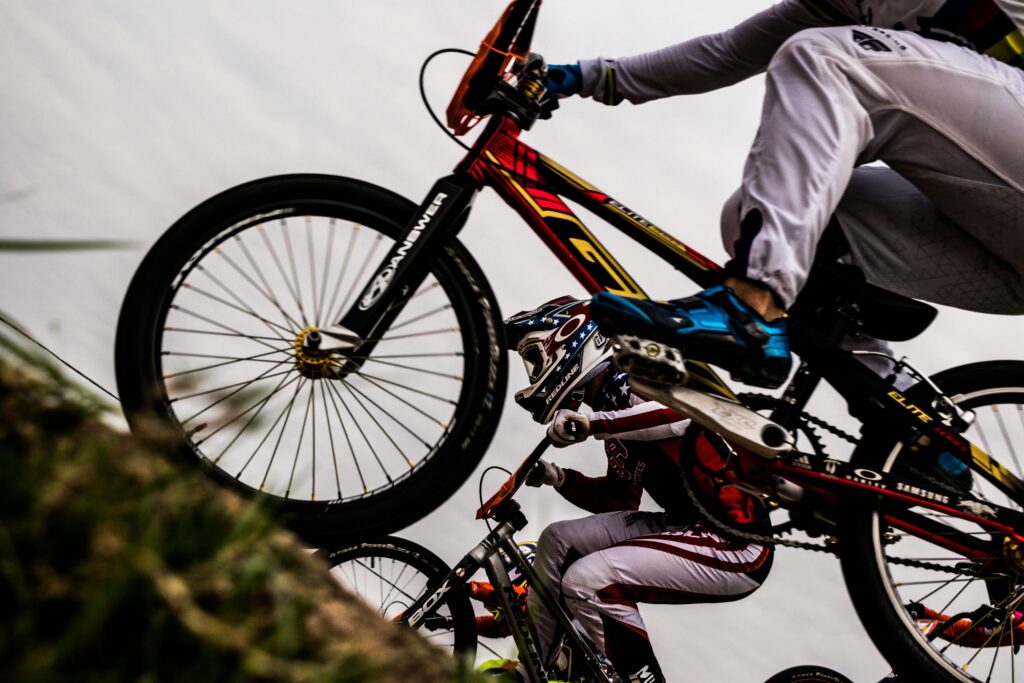 Cyclist and bicycle wheel beside a mountain trail