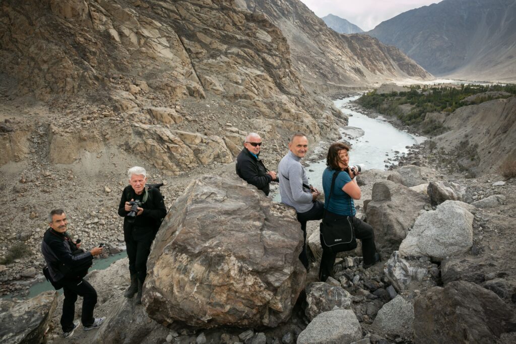 Travellers sitting beside a rocky river
