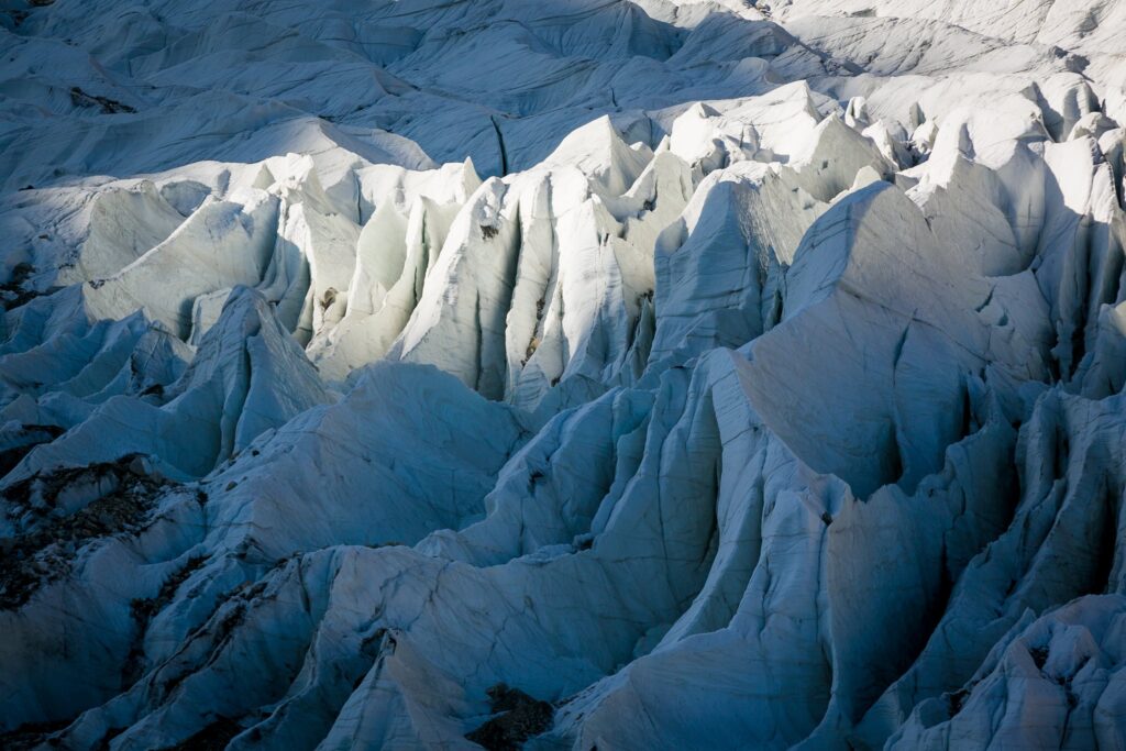 Trekker crossing pale glacier ice