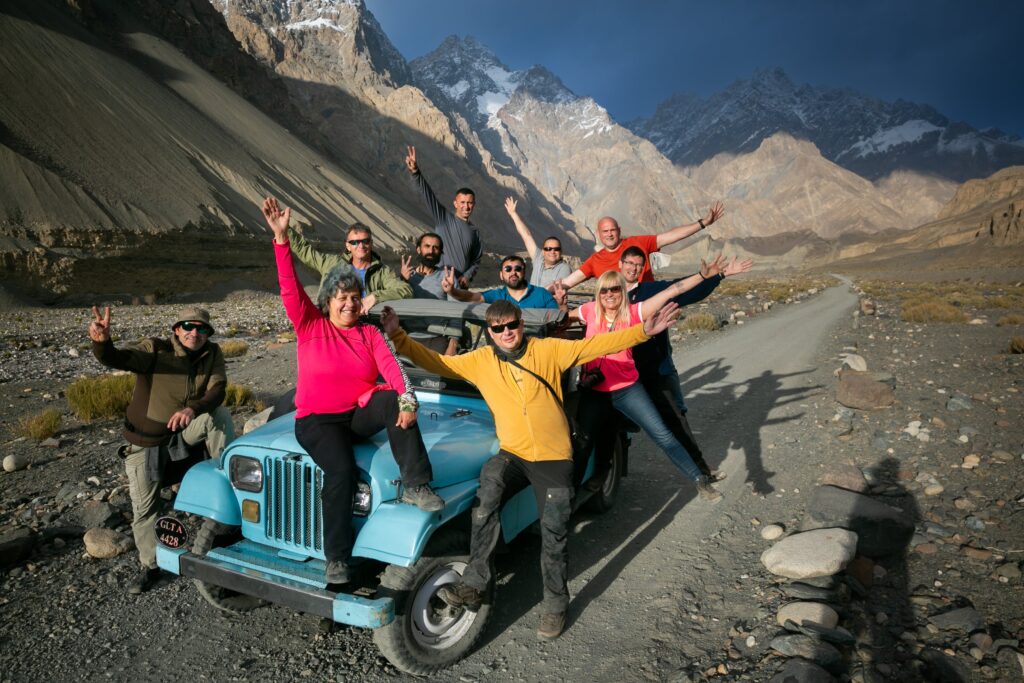 Guests beside a jeep in a mountain valley