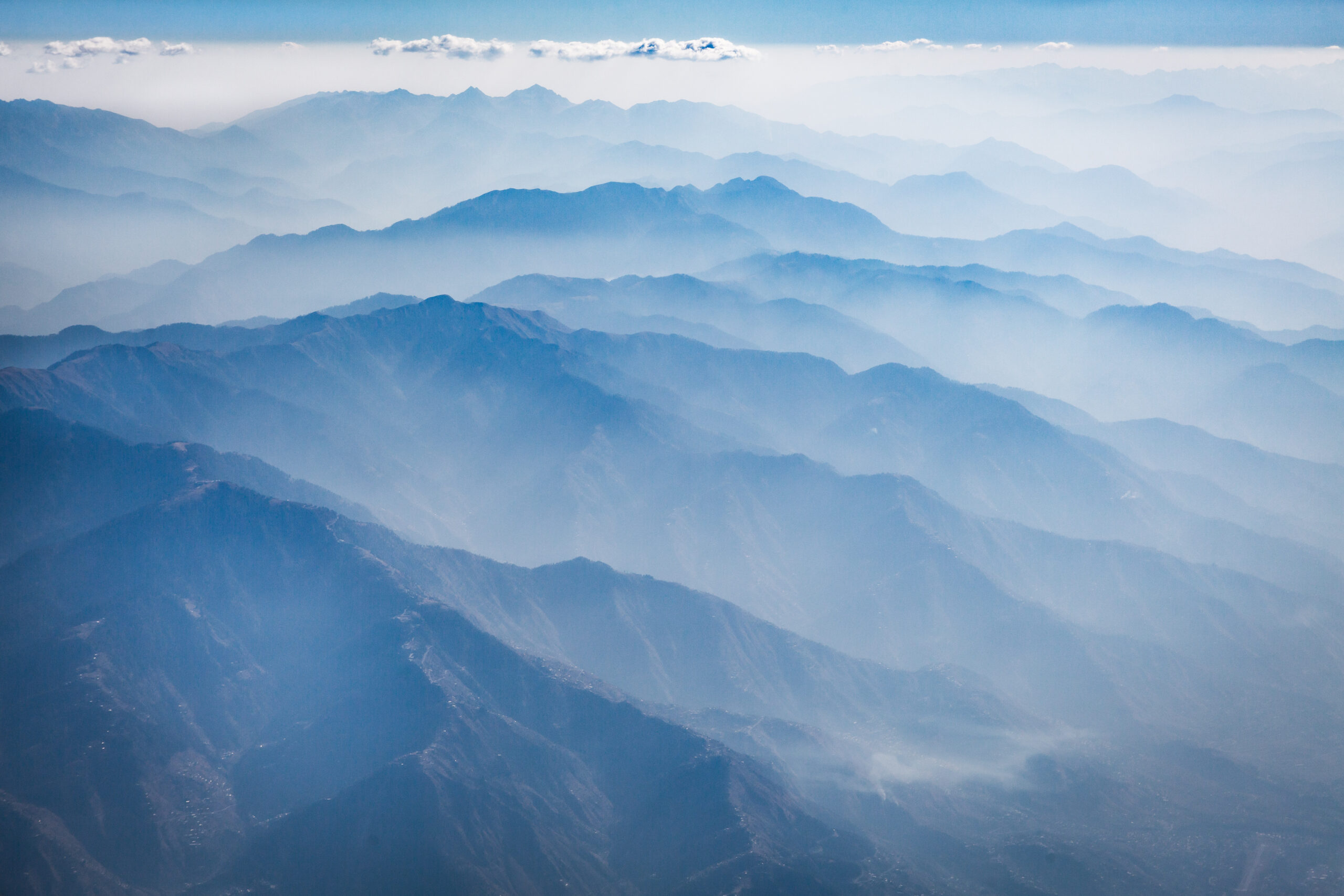 Blue mountain ridges fading into cloud and haze across a wide view in northern Pakistan.