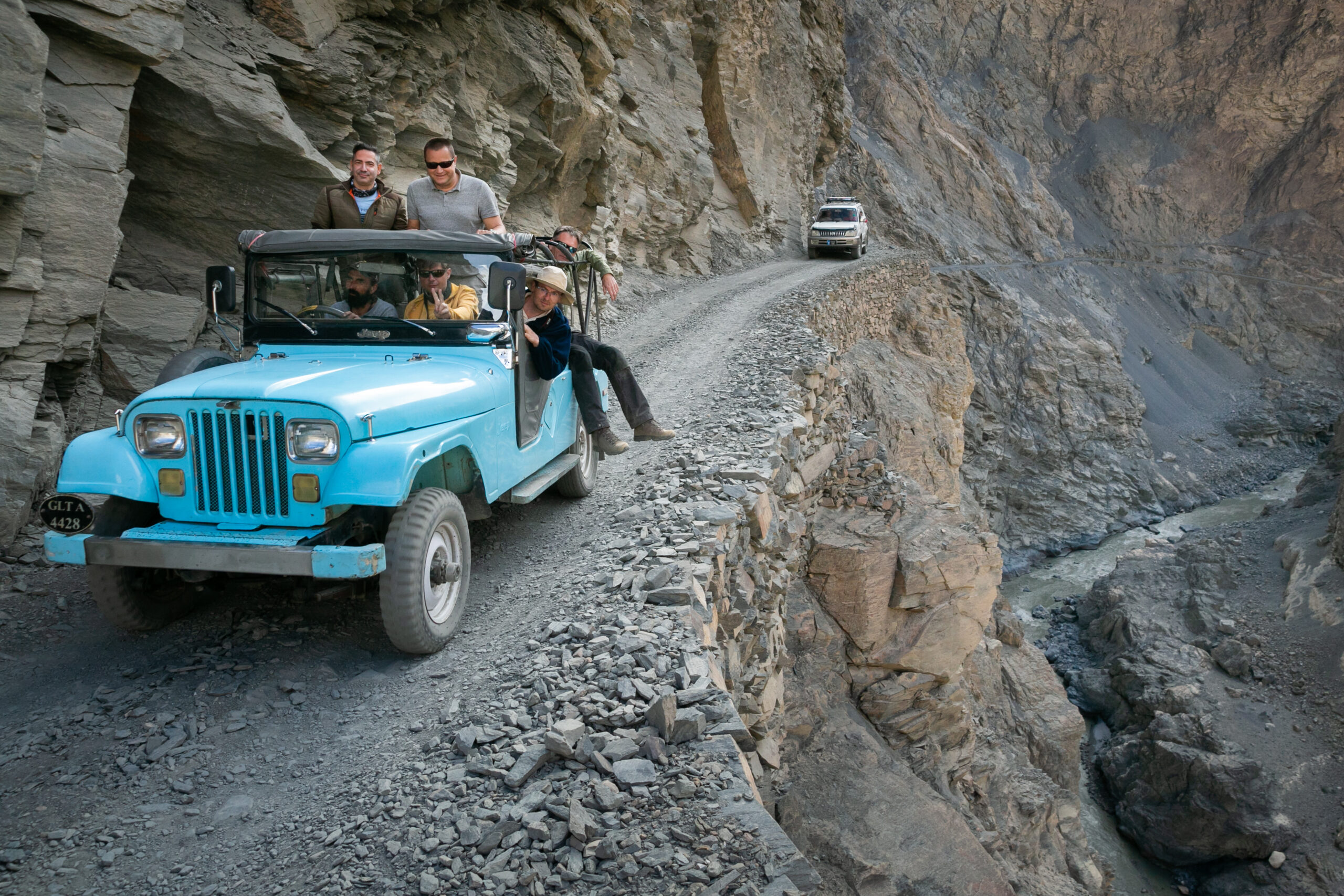 A jeep carrying visitors on the cliff-cut approach road to Shimshal Valley.