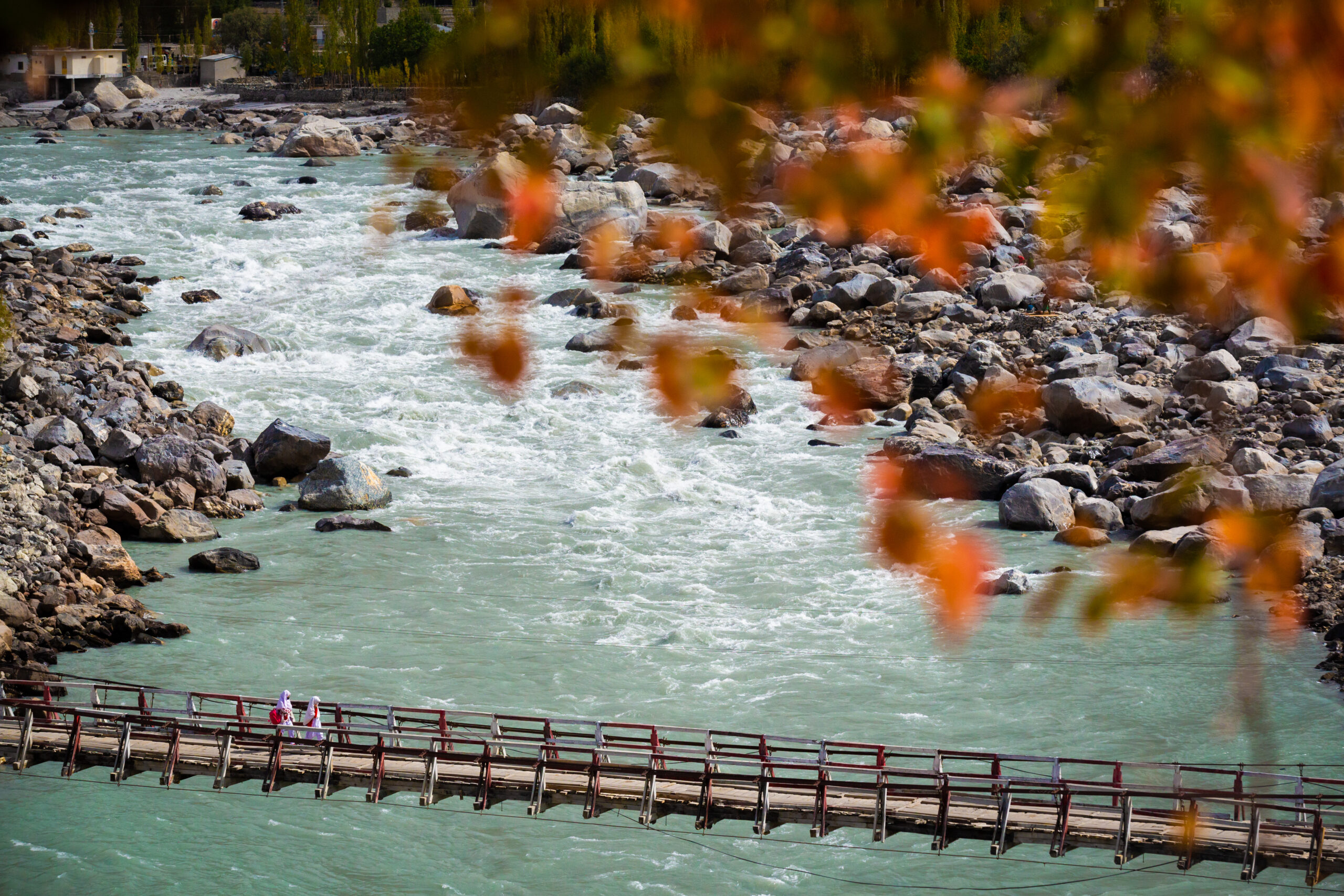 Turquoise water, autumn foliage and a suspension bridge in northern Pakistan.