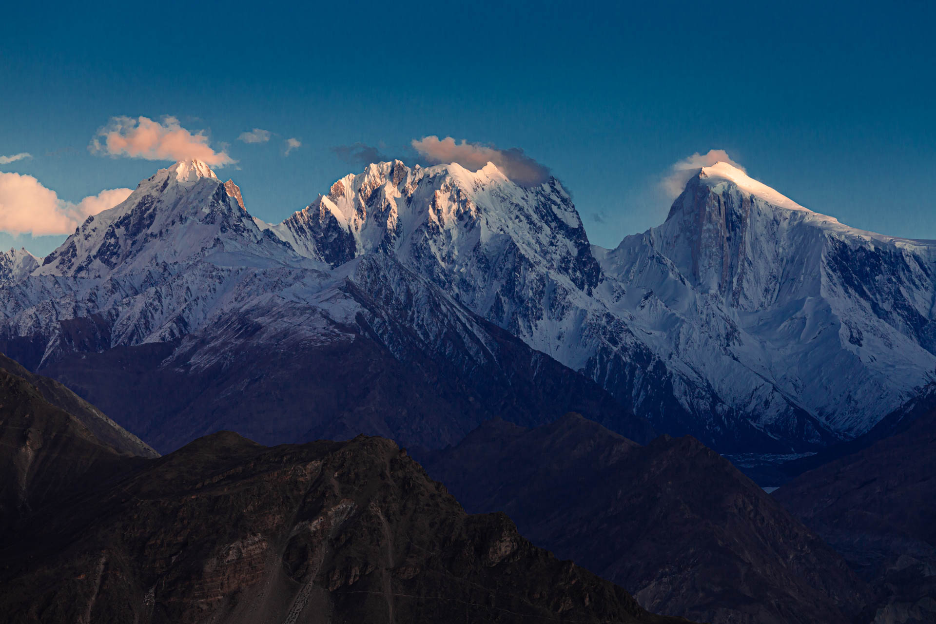 Warm evening light touching a range of snow-covered peaks in northern Pakistan.