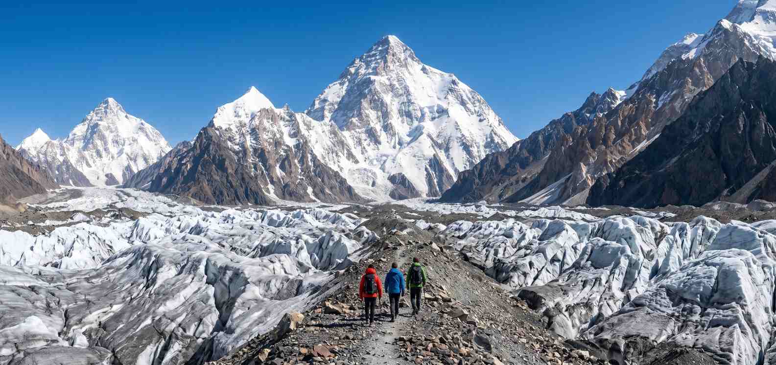 Trekkers approaching K2 Base Camp with the iconic pyramid of K2 visible in the background