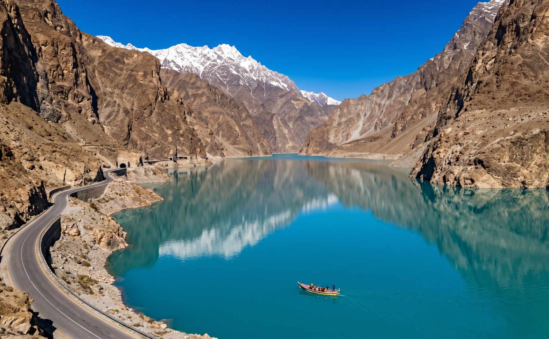 Attabad Lake in Hunza on the Karakoram Highway with turquoise water and mountain walls reflected in the still lake surface