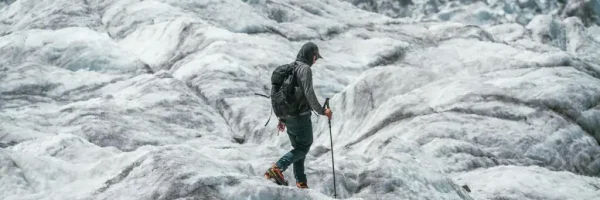 A trekker walking across glacier ice